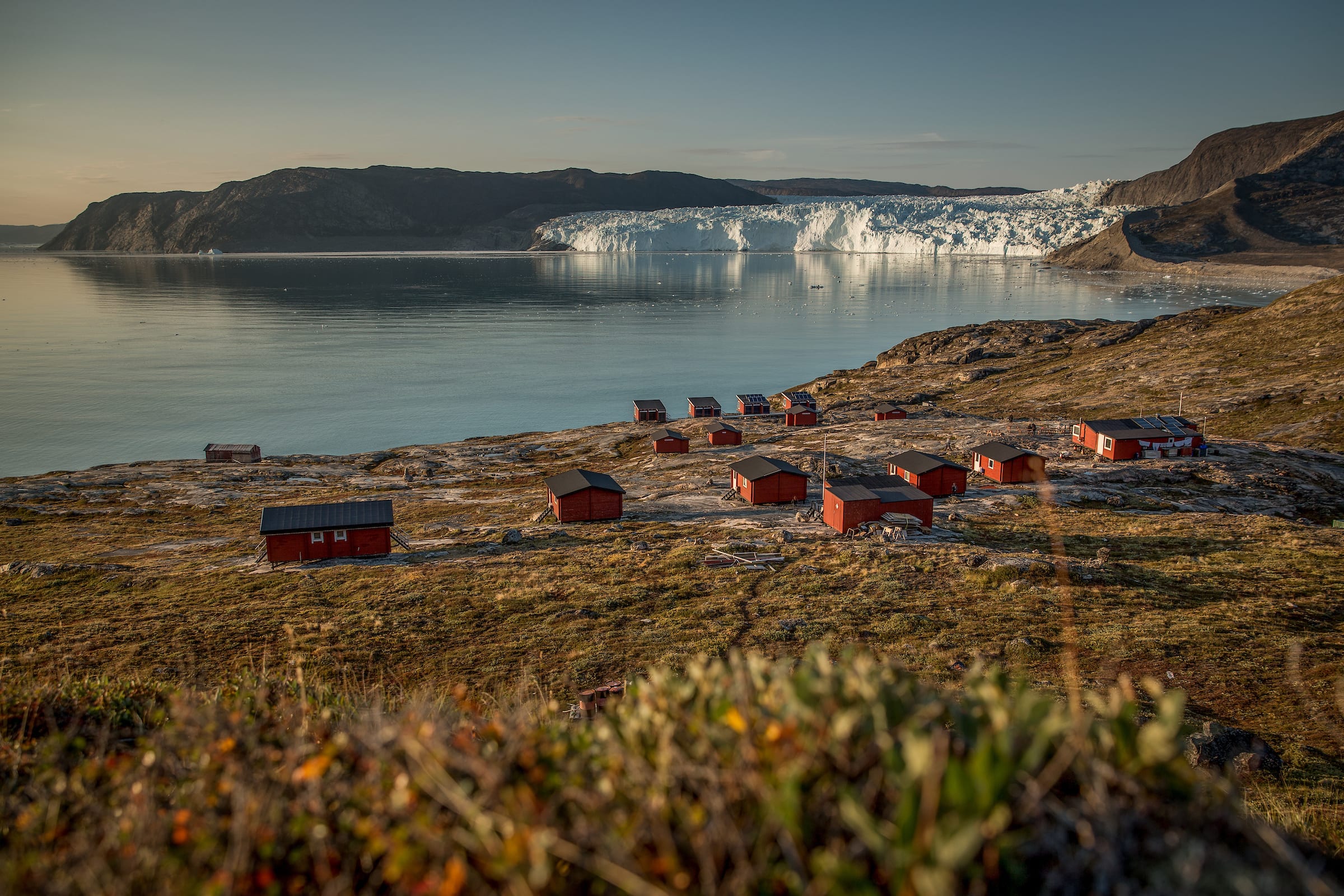 An overview of Glacier lodge Eqi camp with the glacier in the background in northern Greenland - Photographer: Mads Pihl, Visit Greenland