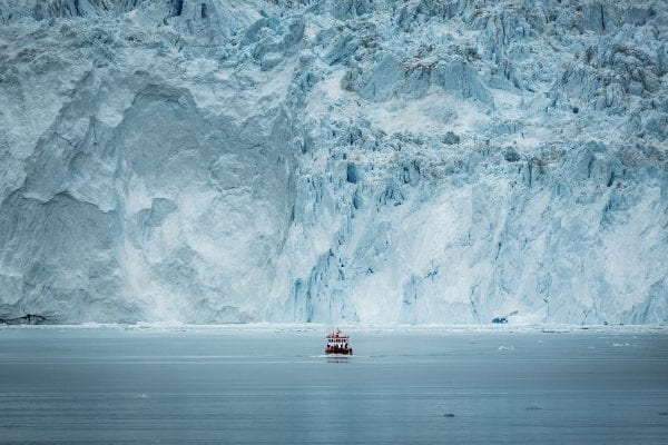 A Small Passenger Boat In Front Of The Huge Glacier Wall At The Eqi Glacier In Greenland - Photo by Mads Pihl - Visit Greenland